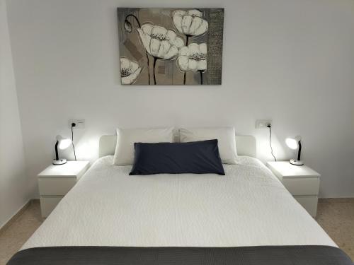 una camera con un letto bianco e 2 lampade di Disfruta a Rafelcofer