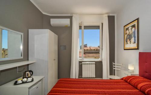sypialnia z czerwonym łóżkiem i oknem w obiekcie City Hotel w Viareggio