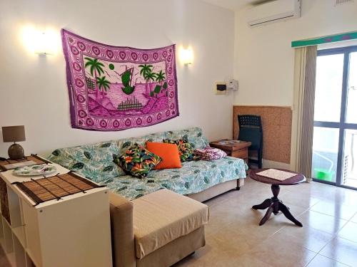 sala de estar con sofá y alfombra en la pared en Flat Cloud 9, en Żebbuġ