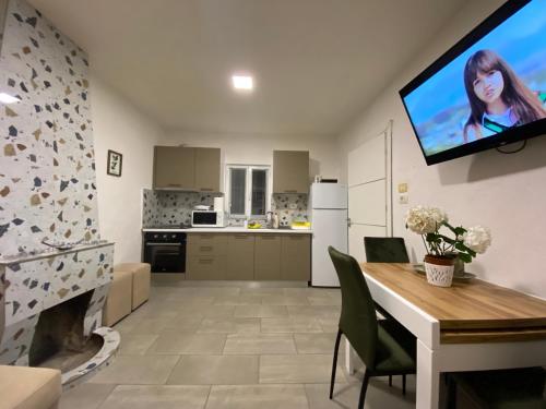 a kitchen and dining room with a tv on the wall at Maison Bellevue - 2 bdrm villa in Borsh beach in Borsh