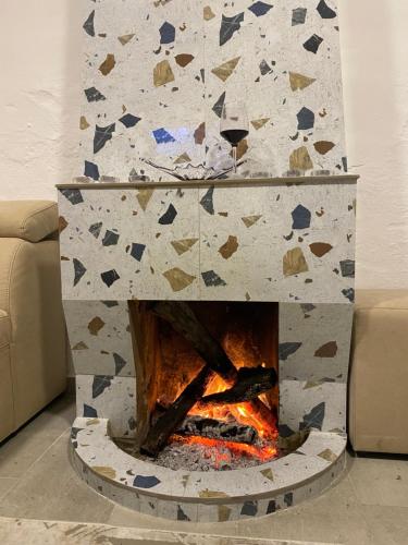 a stone fireplace in a living room next to a couch at Maison Bellevue - 2 bdrm villa in Borsh beach in Borsh