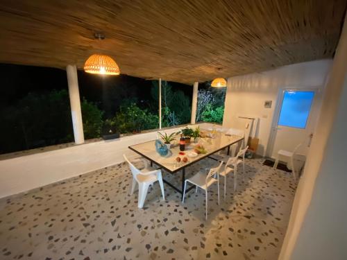 une salle à manger avec une table et des chaises blanches dans l'établissement Maison Bellevue - 2 bdrm villa in Borsh beach, à Borsh