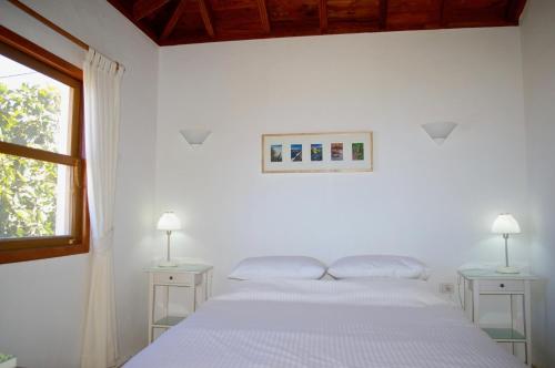 ein weißes Schlafzimmer mit einem Bett und zwei Nachttischen in der Unterkunft Casa Lucia in Puntagorda