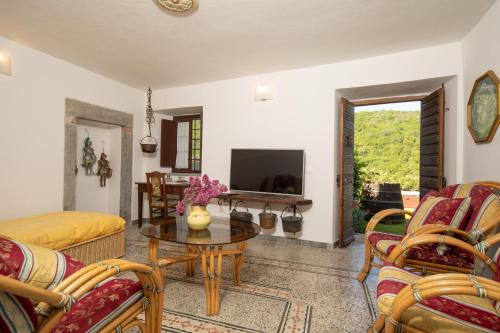 a living room with a table and a tv at Country house with pool and outbuilding Fivizzano by VacaVilla in Terenzano