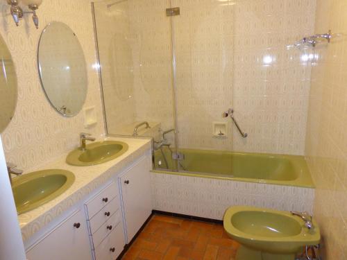 ムジェーヴにあるAppartement REINE DES PRESのバスルーム(洗面台2台、バスタブ、トイレ付)