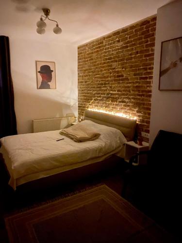 a bedroom with a brick wall and a bed with lights at Green Pipera 1 in Voluntari