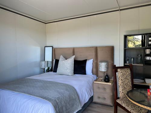 ein Schlafzimmer mit einem Bett, einem Tisch und einem Fernseher in der Unterkunft The Point of View Cabin in Johannesburg