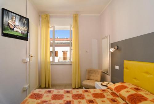 a bedroom with a bed and a tv and a window at City Hotel in Viareggio