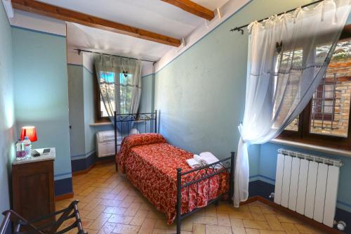 a bedroom with a bed in a room with a window at Albergo Diffuso Borgo Montemaggiore in Montemaggiore al Metauro
