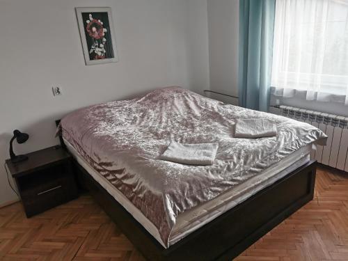 a bed with a silver comforter in a bedroom at DUKAT in Horyniec Zdrój