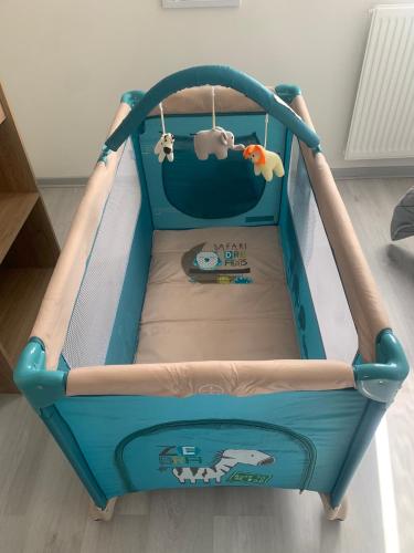 - un lit bébé bleu dans une chambre avec semblant dans l'établissement La maison de ville - 4 chambres, 2 sdb, terrasse et garage - 90m2, à Vesoul