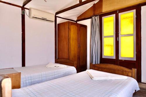 a bedroom with two beds and two windows at Bedouin Valley Eco Resort in Marsa Alam City