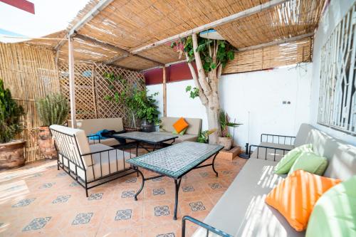 a patio with a table and chairs and a table at Original Surf Morocco in Tamraght Ouzdar