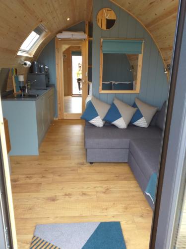 a living room with a couch in a tiny house at North Star Glamping in Lybster