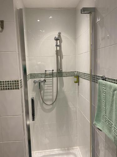 een douche in een badkamer met een glazen deur bij Rossdene House in Blackpool