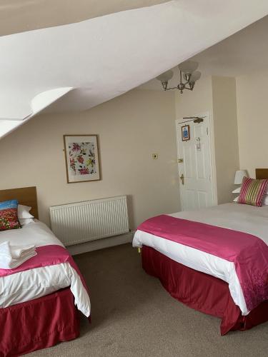 um quarto com 2 camas com lençóis vermelhos e brancos em Rossdene House em Blackpool