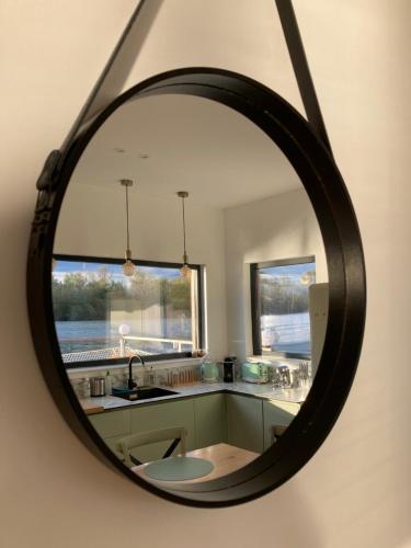 un miroir dans une cuisine avec un évier et une fenêtre dans l'établissement SeineHouse - Maison flottante (HouseBoat) - Séjour magique sur l'eau, à Vaux-sur-Seine
