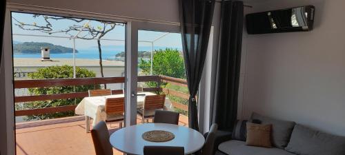 een woonkamer met een bank en een tafel en een balkon bij Apartments Borić in Cres