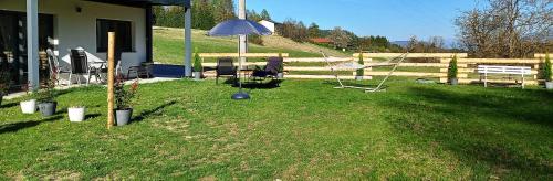 un cortile con ombrellone, panchina e recinto di Dingsbums a Unteraichwald