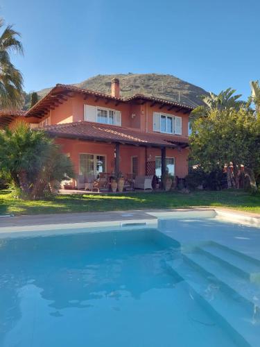 a house with a swimming pool in front of it at Villa Di Giorgi Apartments in Cefalù