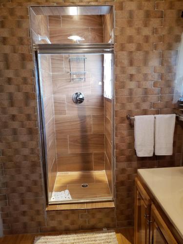 a shower with a glass door in a bathroom at Cliffe Ranch in Mandeville