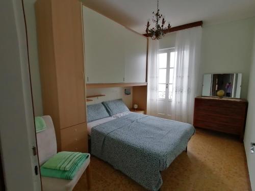 ein Schlafzimmer mit einem Bett, einem Stuhl und einem Fenster in der Unterkunft Residenza Il Gabbiano 2 - panoramic rooms in Cannobio