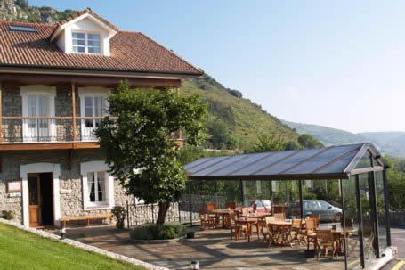 uma casa com um gazebo, uma mesa e cadeiras em Vivienda vacacional Las Viñas em Oviedo