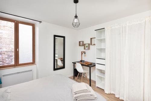 a bedroom with a bed and a desk and a window at Dominici 1-CahorsCityStay-Centre Clim Netflix in Cahors