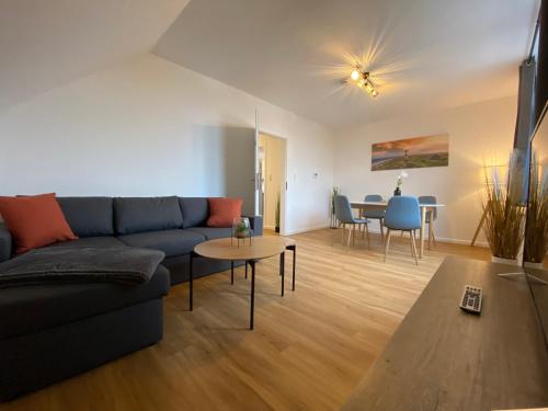 a living room with a blue couch and a table at Charmante Altbauwohnung an der Kesselschleuse 3 in Emden