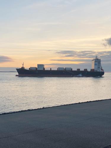 a large container ship in the water at sunset at Het sfeerhuis aan zee in Vlissingen