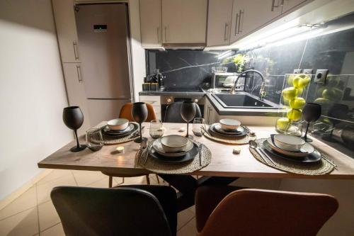 a kitchen with a wooden table with plates and glasses at Elite and Style in Preveza