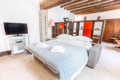 a bedroom with a bed and a flat screen tv at CANAL DREAM cosy apartment with canal view in Venice