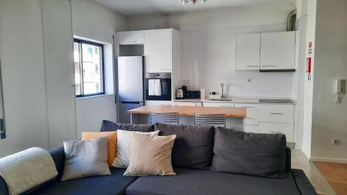 a living room with a couch and a kitchen at Lovely 2-bedroom apartment - near Braga city center! in Braga