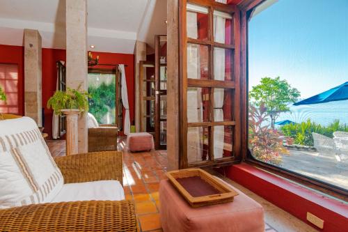 a living room with a large window with a view at Villas Jardin Del Mar in Cruz de Huanacaxtle
