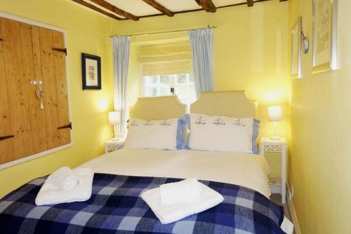 a bedroom with a bed with two towels on it at Thornwell Cottage - Heart of the village, amazing gardens, glorious views and brimming with character in Dittisham