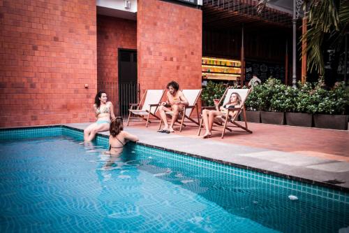 a group of women sitting around a swimming pool at Villa 25 in Rio de Janeiro