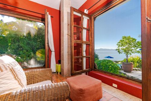 Cette chambre dispose d'un canapé et d'une grande fenêtre. dans l'établissement Villas Jardin Del Mar, à La Cruz de Huanacaxtle