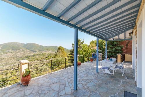 a patio with a table and a view of the mountains at Villa Galazopetra in Skopelos Town