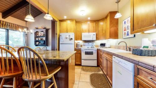 a kitchen with wooden cabinets and white appliances at Discover 4 in Mammoth Lakes