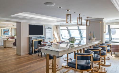 a kitchen and living room with a bar and chairs at The Langham, Boston in Boston