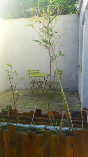 une table verte et un banc dans une cour dans l'établissement STUDIO PROCHE DE LA MER, à Agon-Coutainville