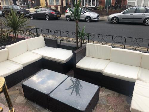 a group of white couches and tables on a street at Leecliff Guest House in Blackpool