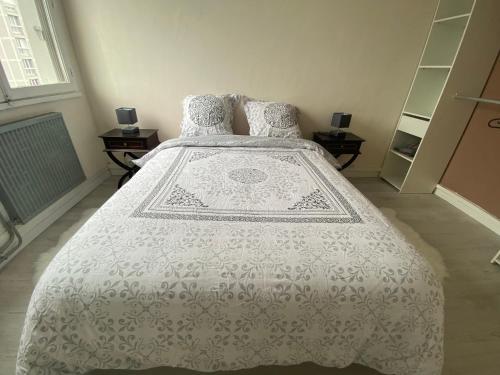 sypialnia z łóżkiem z białą kołdrą w obiekcie Appartement, parking gratuit, sortie, autoroute, la méridienne w mieście Clermont-Ferrand