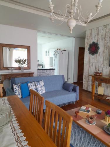 uma sala de estar com um sofá azul e uma mesa em Casa Caminho da Serra em Tiradentes