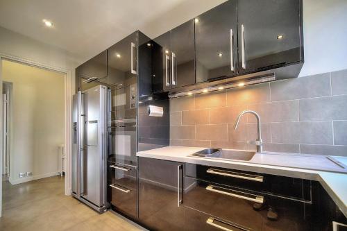 une cuisine avec un évier et un réfrigérateur dans l'établissement IMMOGROOM - Large Apartment - Parking - Air conditioning - Sea view - Wifi, à Cannes