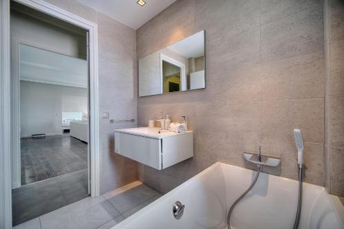 une salle de bain avec une baignoire, un lavabo et un miroir dans l'établissement IMMOGROOM - Large Apartment - Parking - Air conditioning - Sea view - Wifi, à Cannes