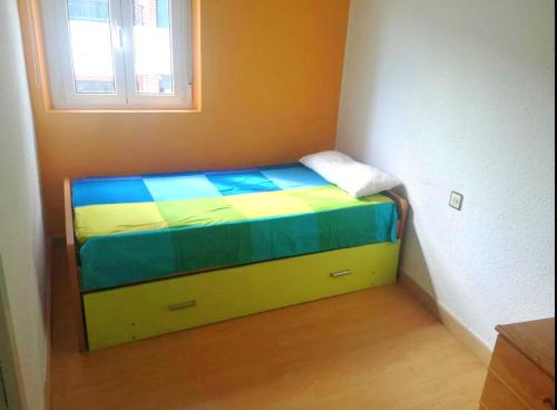 a small bed in a room with a window at Santoña Paseo Marítimo 2ª linea playa, Llegada autónoma, Wifi in Santoña