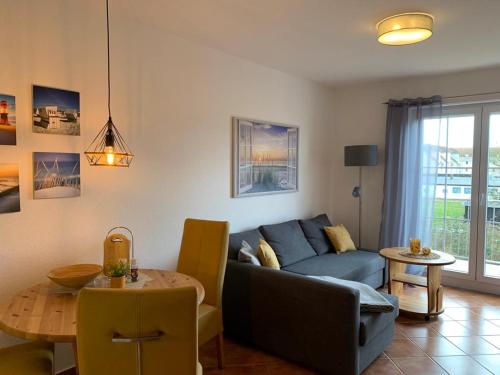 un soggiorno con divano blu e tavolo di Meerjungfrau a Insel Poel