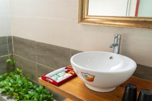 a white sink on a wooden counter in a bathroom at Khu Nghỉ Dưỡng Green Bungalow Phu Quoc in Phu Quoc
