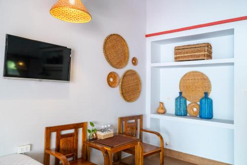 a living room with a tv and a table and chairs at Khu Nghỉ Dưỡng Green Bungalow Phu Quoc in Phu Quoc